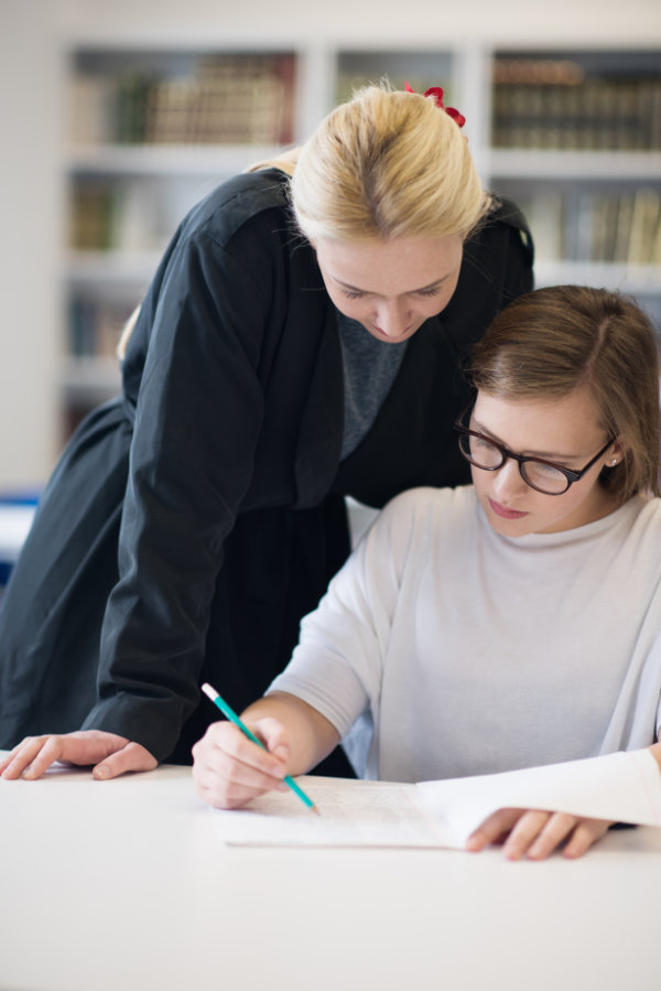 female teacher helping students on class